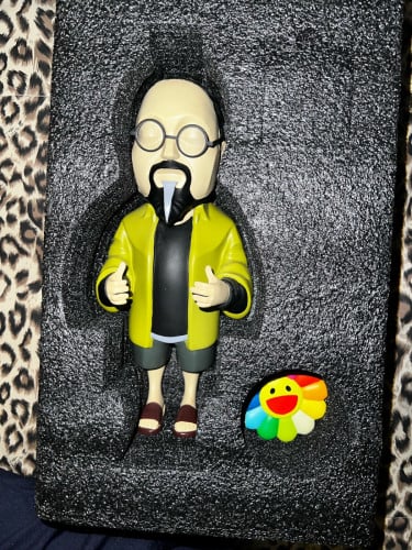 collectible figure of Japanese artist Takashi Murakami and "Kaikaikiki" rainbow flowers.