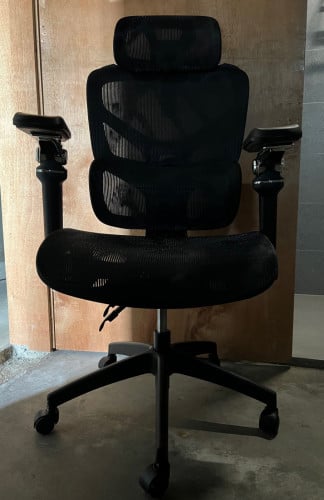 an ergonomic office chair in black mesh.