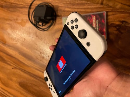 Nintendo Switch Oled 64GB មានឆ្នាំងសាក ថែម Game Card Hyrule Warriors តម្លៃ 160$