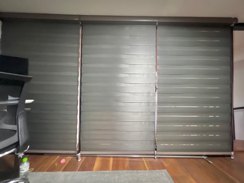 Bed&office space covered by blinds and curtains